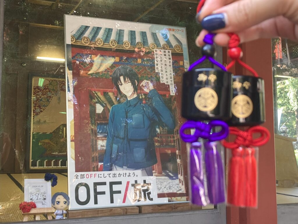 久能山東照宮の印籠守をOFF／旅パネル（和泉一織のピンショット）の前で掲げている写真